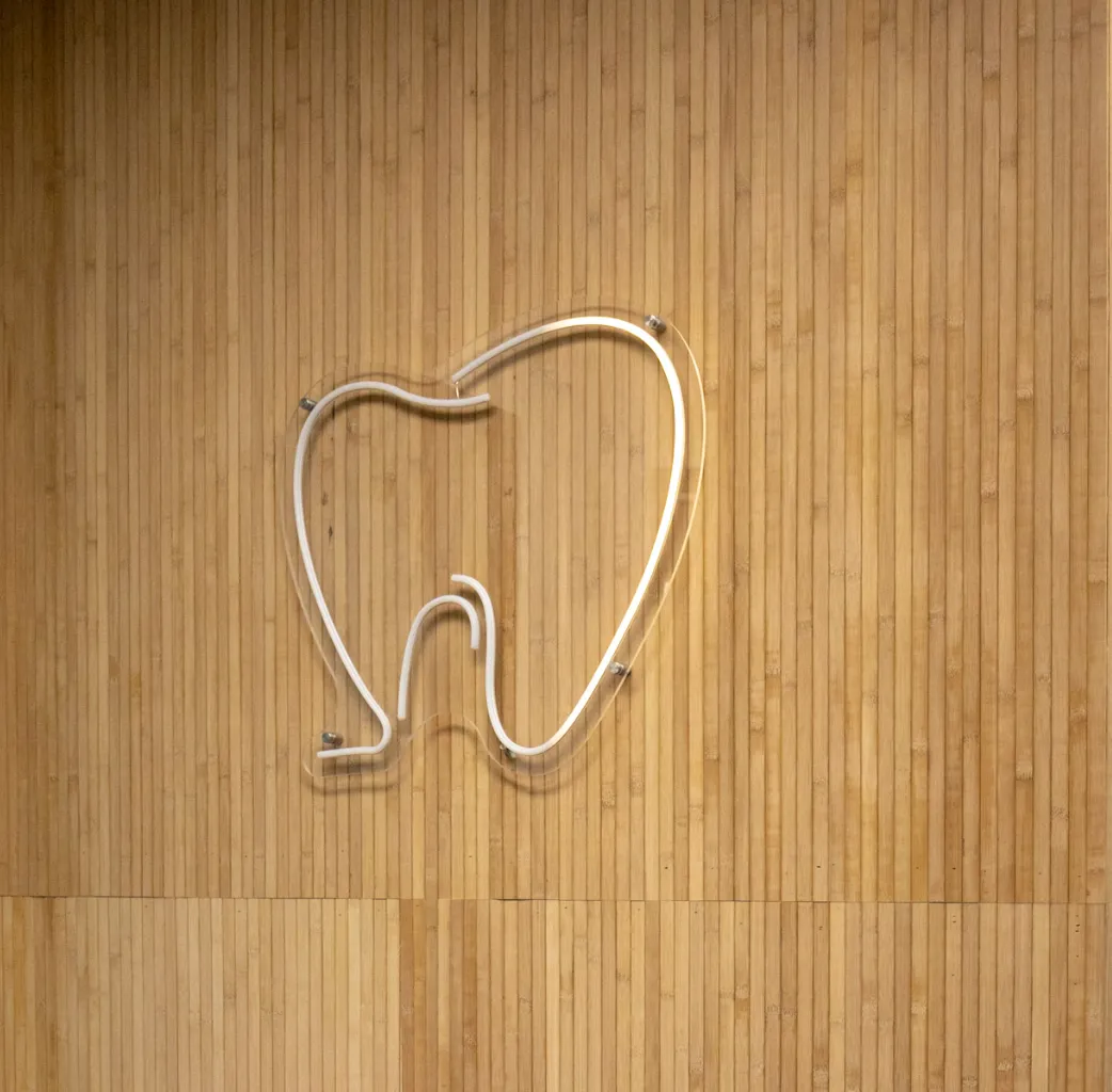 A tooth-shaped light fixture on a wood office wall